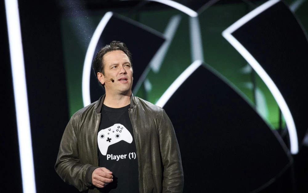 Phil Spencer Phil Spencer, Head of Xbox, speaking at an Xbox event with the company logo in the background.