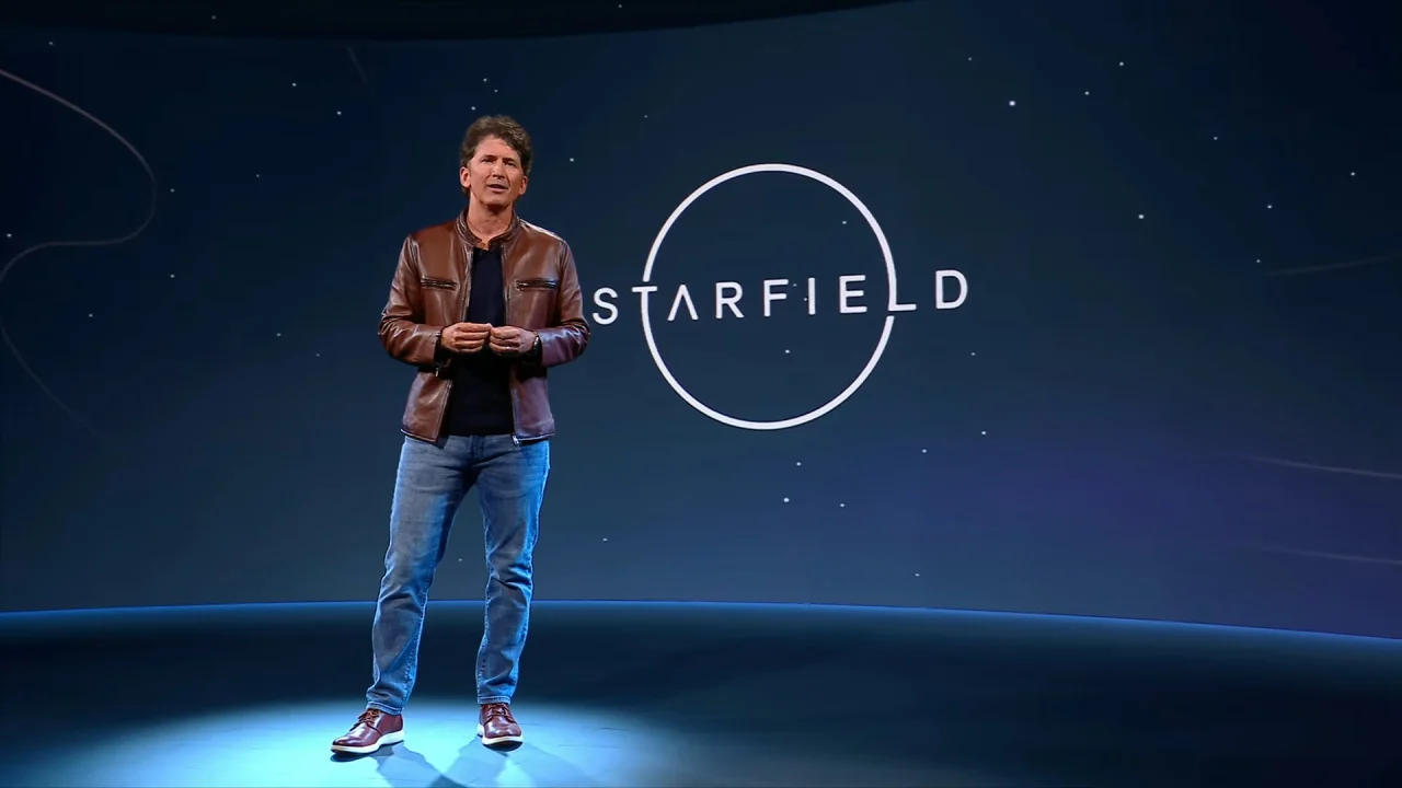 Todd Howard Todd Howard, Head of Bethesda Studios, speaks about upcoming game Starfield with the game's title on a screen in the background behind him.