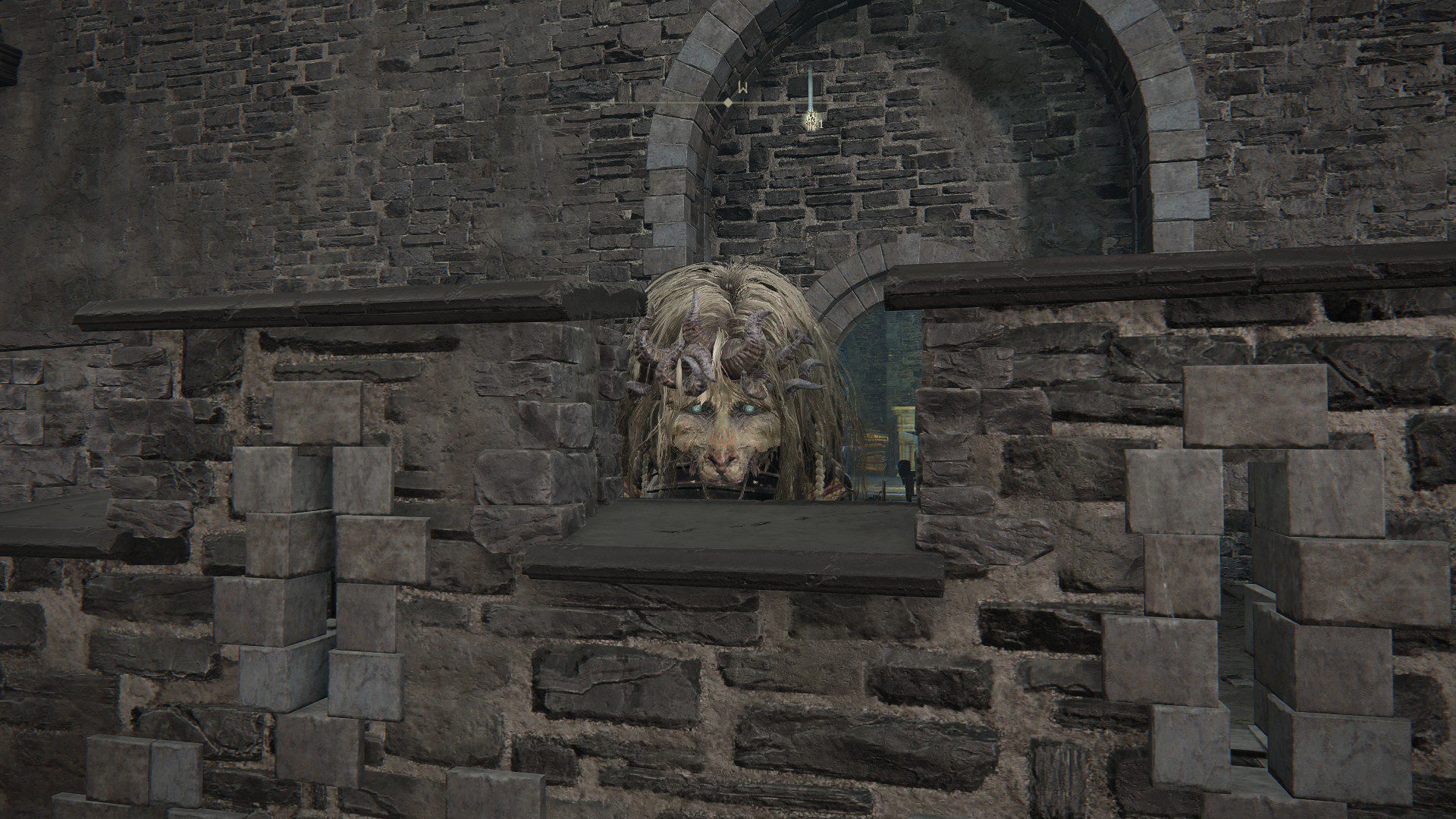 A giant horned, lion head peeking through the stone