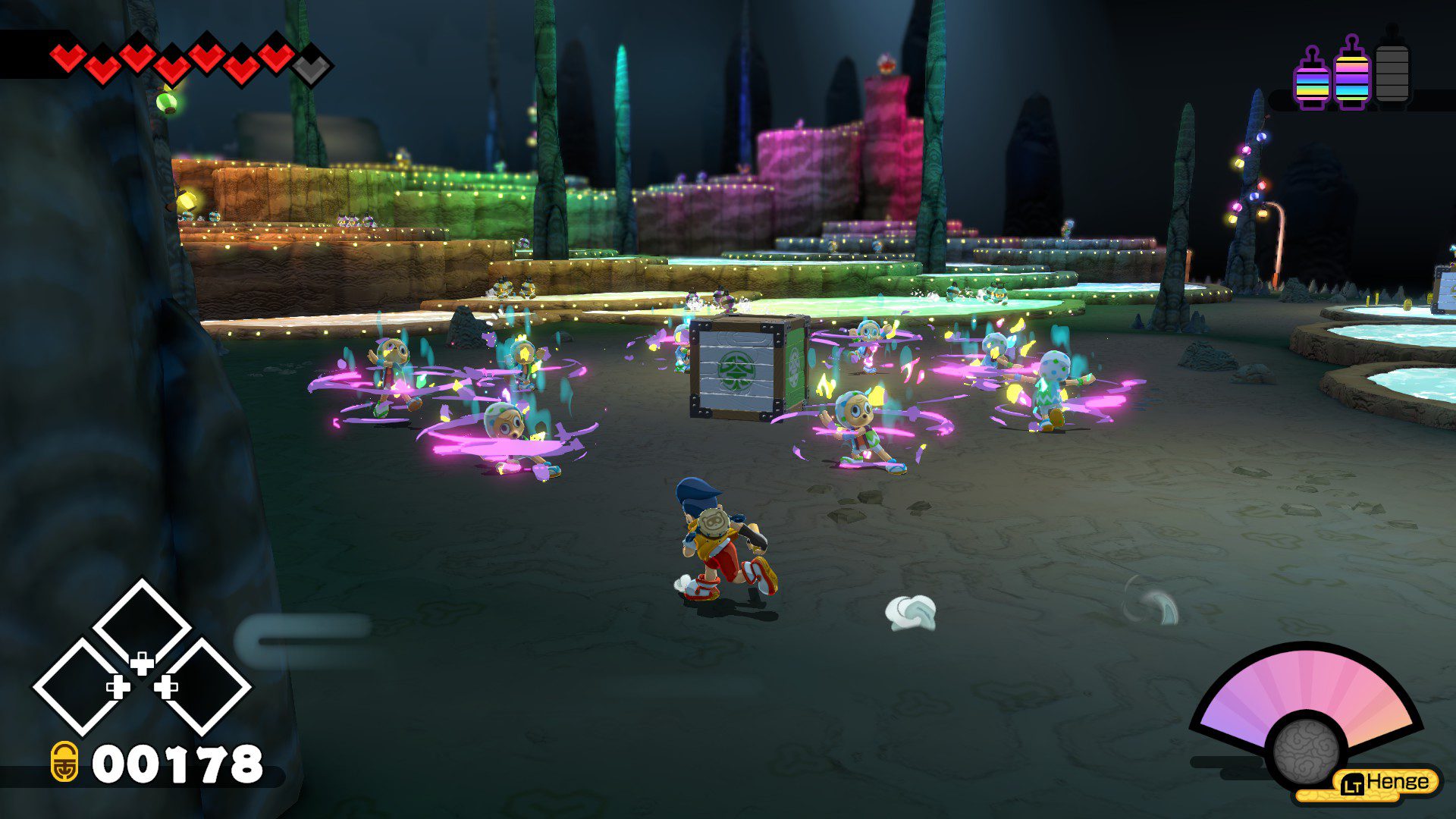 Enemies in masks dancing around a crate in a colorful cave