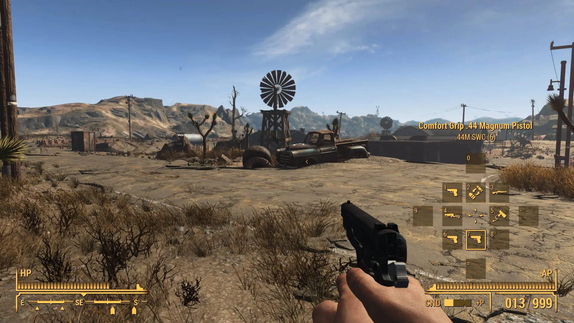 First-person perspective of a character holding a .44 Magnum pistol in a desert wasteland from Fallout: New Vegas