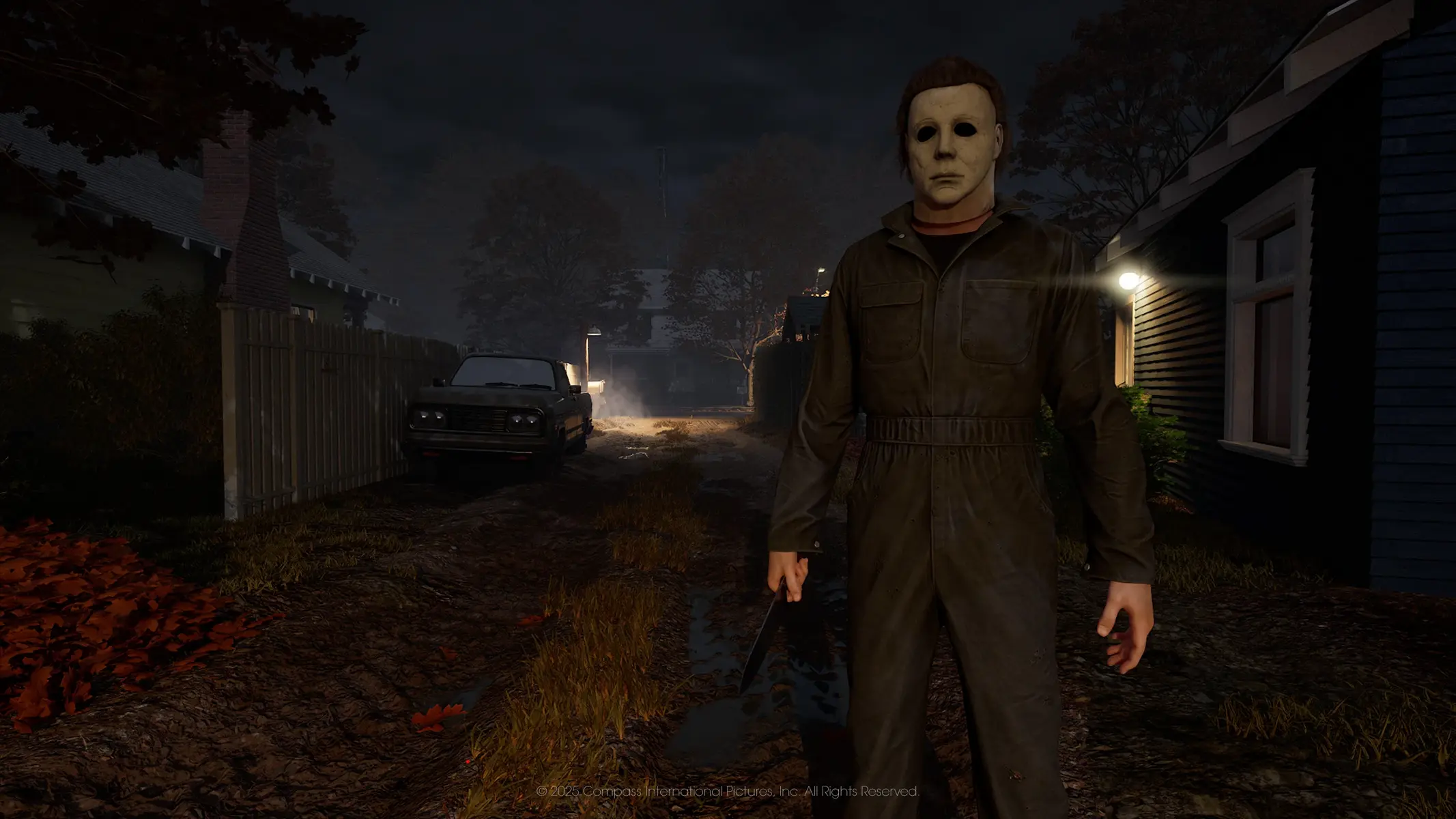 Michael Myers wearing a white mask and dark coveralls holding a knife in a dark residential neighborhood