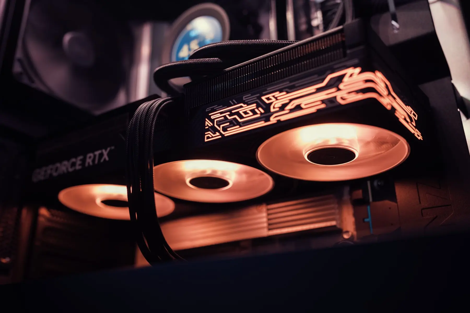Close-up of an Nvidia GeForce RTX graphics card with glowing orange lighting inside a PC case